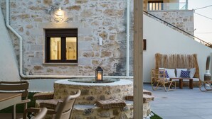 A stone exterior with a window, outdoor seating, and a staircase.