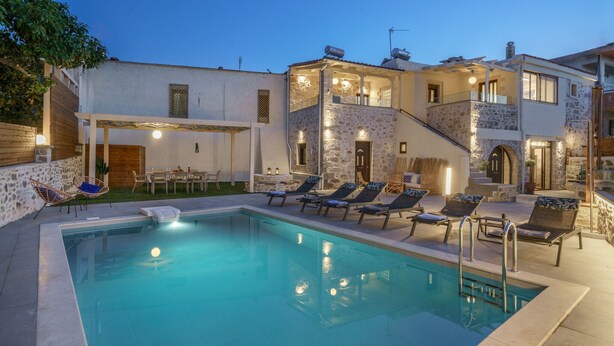 A poolside area with lounge chairs and a dining table.