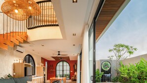 A modern interior with a dining area, a poolside area, and a staircase. - The Foglia Canggu (Canggu)