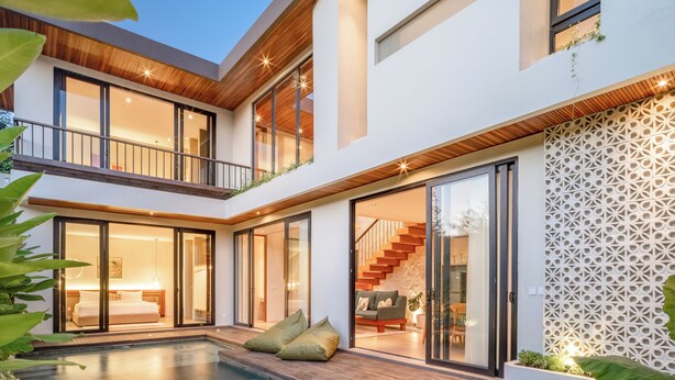 A modern two-story house with a swimming pool, large windows, and a wooden deck. - The Foglia Canggu (Canggu)