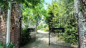 A gated entrance to a property with a brick wall and a sign that reads "albergoes."