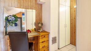 A room with a wooden desk, a chair, a mirror, a fan, and a wardrobe. - Apartment “Haus Fabio” with Private Terrace and Wi-Fi (Engstingen)