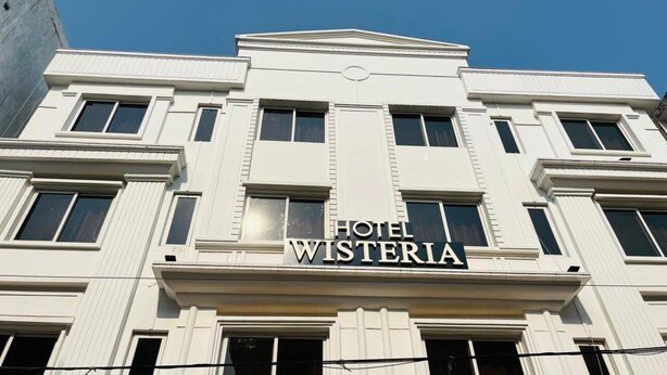 Een gebouw met een bord waarop 'HOTEL WISTERIA' staat.