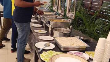 A buffet setup with various food items and utensils.