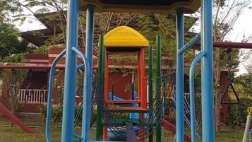 A playground structure with a yellow roof, blue and red support beams, and a slide.