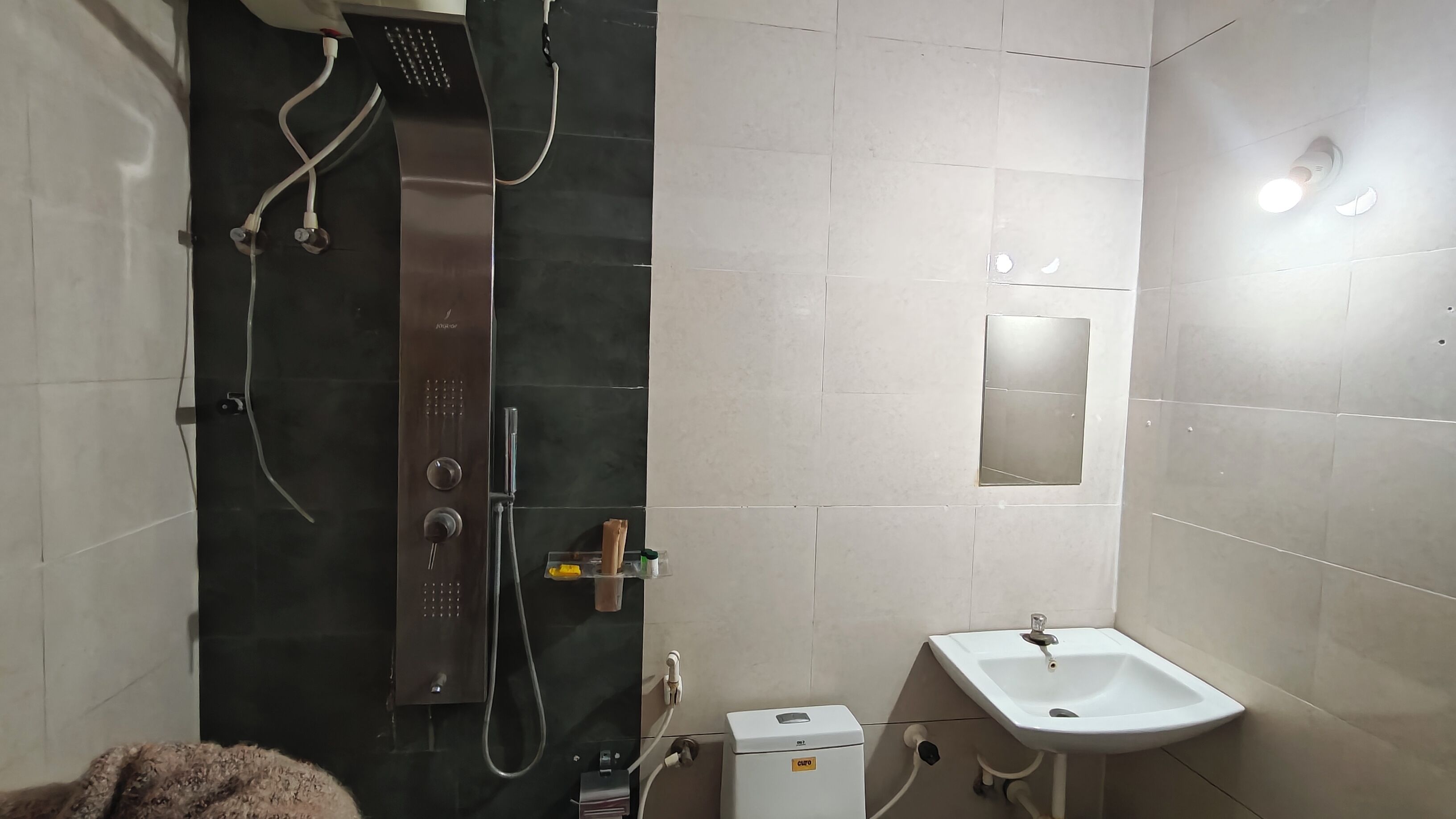 Un baño con ducha, lavamanos y espejo.