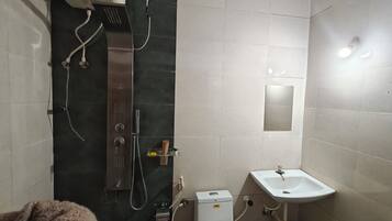 Un baño con ducha, lavamanos y espejo.