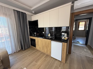 A modern kitchen with a black countertop, white cabinets, and a built-in dishwasher.