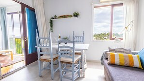 A room with a dining table, chairs, a sofa, and a window with a view. - Beautiful apartment with spectacular views, pool and close to the beach! (Pals)