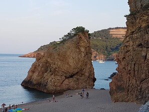 A beach with large rock formations and a clear view of the sea.