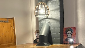 Ein Kamin aus Ziegelsteinen mit einer modernen Metallhaube und einer Holzauskleidung.