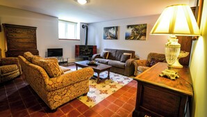 A living room with patterned sofas, a coffee table, a TV, and a fireplace.