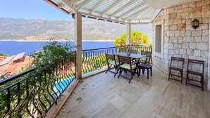 A covered outdoor seating area with a view of the sea and mountains. - Villa Noa Amazing Sea view (Kas)