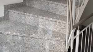 A staircase with granite steps and a metal handrail. - Rottenburg City 4 rooms with cathedral view (Rottenburg)