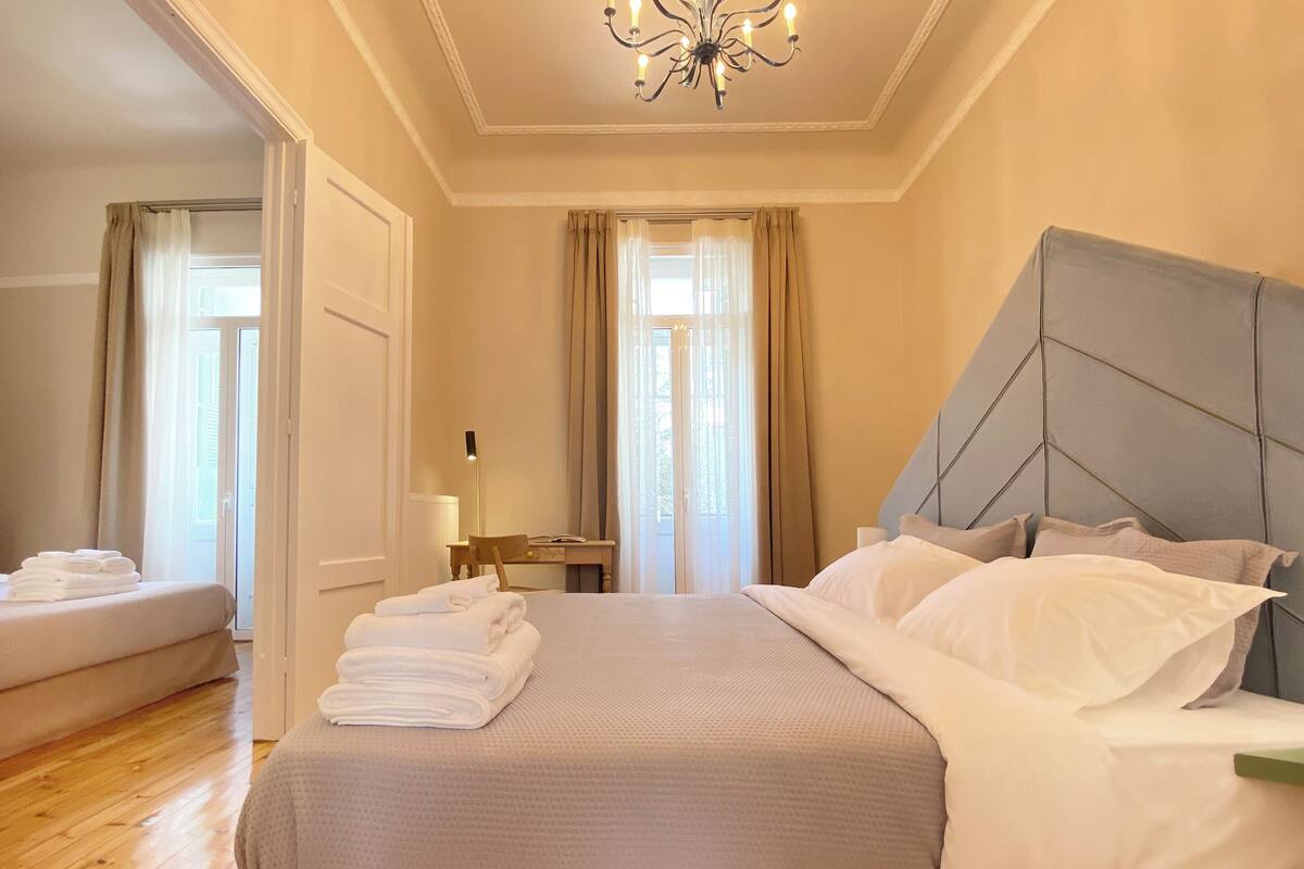 Une chambre d’hôtel avec un grand lit, une table de chevet, un bureau et une chaise.