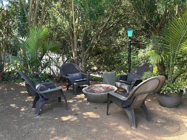 An outdoor seating area with wicker chairs and a fire pit.