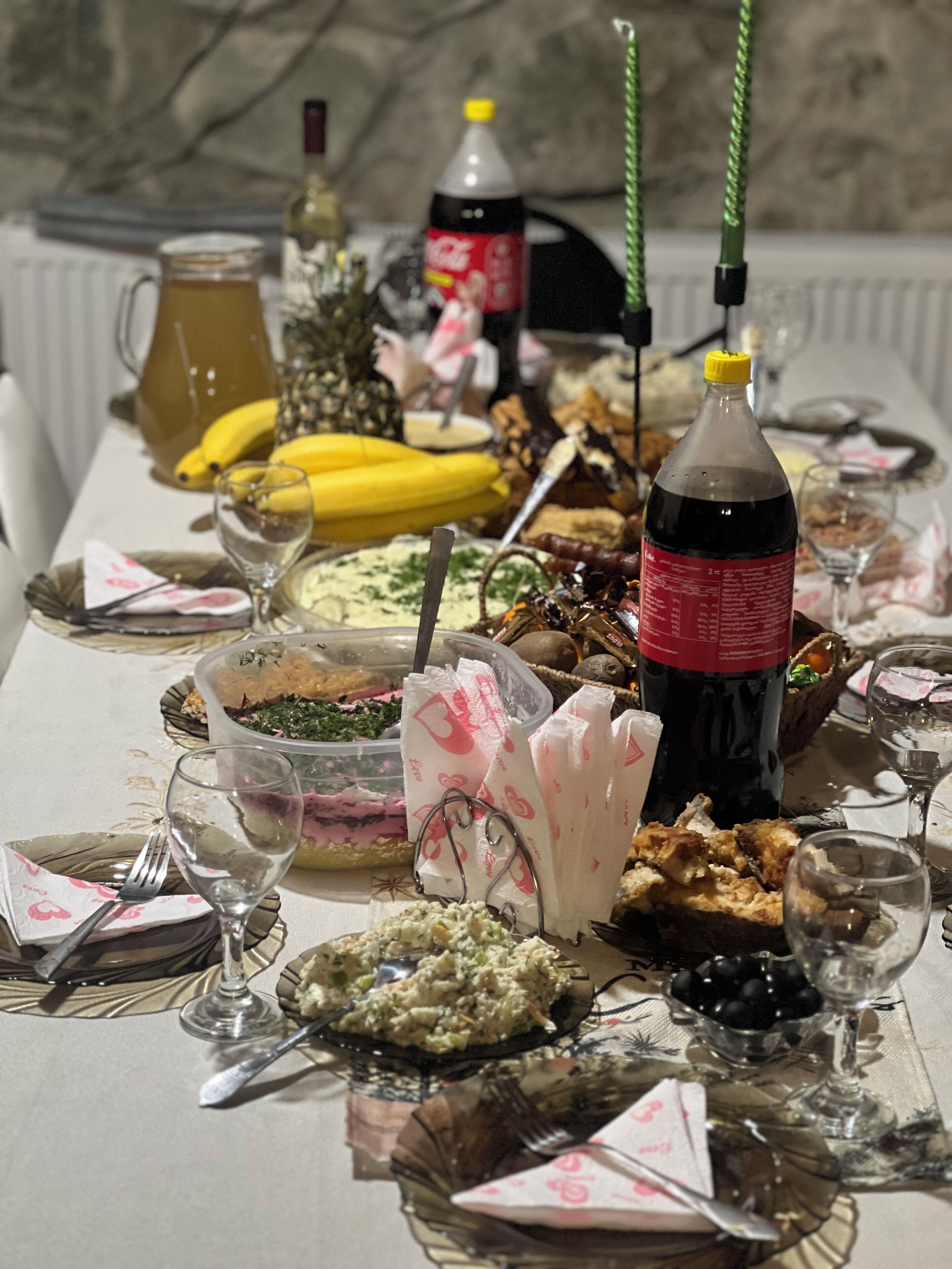 Una larga mesa de comedor con diversos platos, bebidas y utensilios.