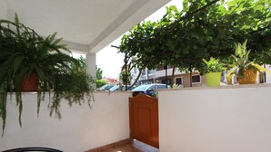 A balcony with a table, chairs, and potted plants. - Studio Vera (Rovinj)
