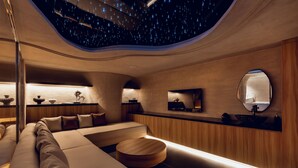 A modern interior with a curved ceiling, a seating area, and a wooden wall with a mirror. - KiN Hotel Onsen  (Ho Chi Minh City)