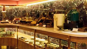 Un buffet de petit-déjeuner proposant une variété d’aliments et un coin café.