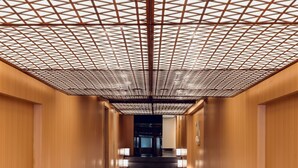A corridor with wooden walls, a patterned ceiling, and illuminated lanterns. - KiN Hotel Onsen  (Ho Chi Minh City)