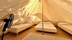 A tent with three beds, a fan, and a small table. - Nirikos Camping (Lefkada)