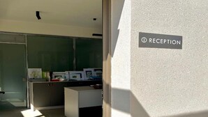 A reception area with a sign reading "RECEPTION" on a textured wall. - Nirikos Camping (Lefkada)