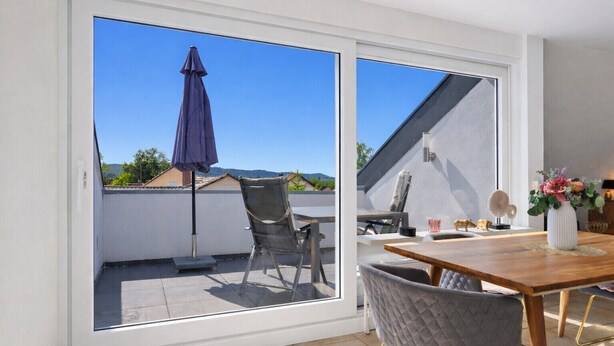 A balcony with a table, chairs, and a potted plant. - Casa di Napolitano at Lake Constance – Modern Attic Apartment Near the Lake (Radolfzell am Bodensee)