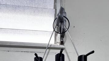 Three bottles of hair care products on a metal rack against a wall.
