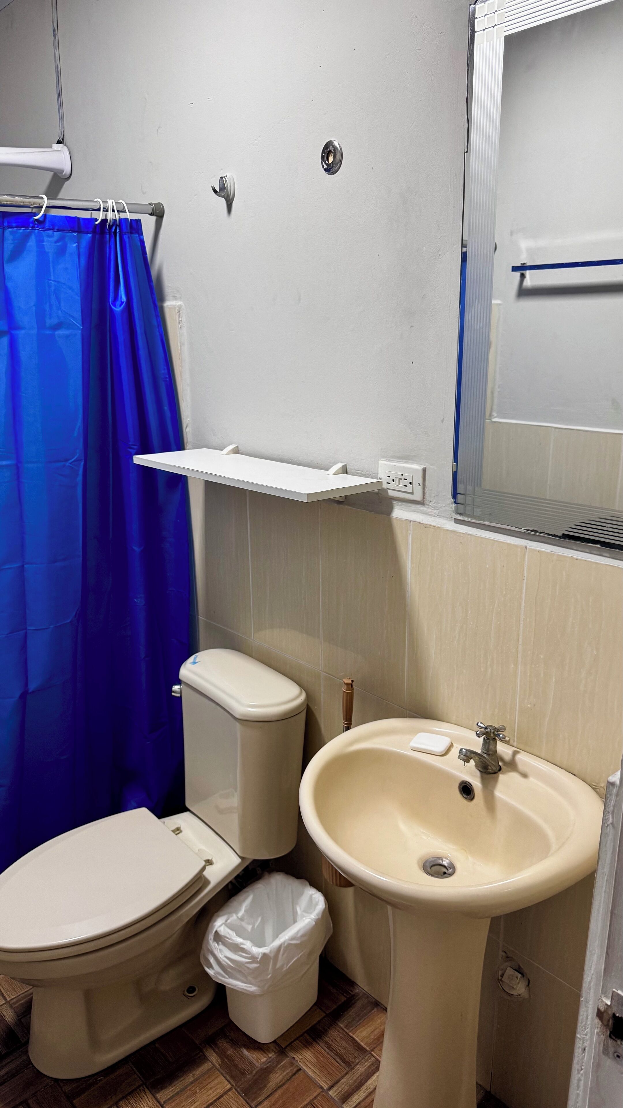 Une salle de bain équipée de toilettes, d’un lavabo et d’un rideau de douche.