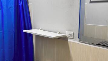 Une salle de bain équipée de toilettes, d’un lavabo et d’un rideau de douche.