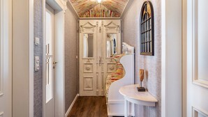 A hallway with a patterned ceiling, a white door, a mirror, and a white chair. - Holiday Home 'Ferienhaus Barockhaus Fulda' with Private Terrace, Private Garden and Wi-Fi (Petersberg)