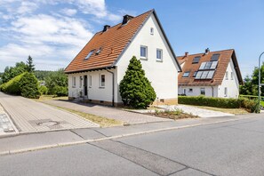 A residential area with two houses, one with a sloped roof and solar panels, and the other with a flat roof. - Holiday Home 'Ferienhaus Barockhaus Fulda' with Private Terrace, Private Garden and Wi-Fi (Petersberg)