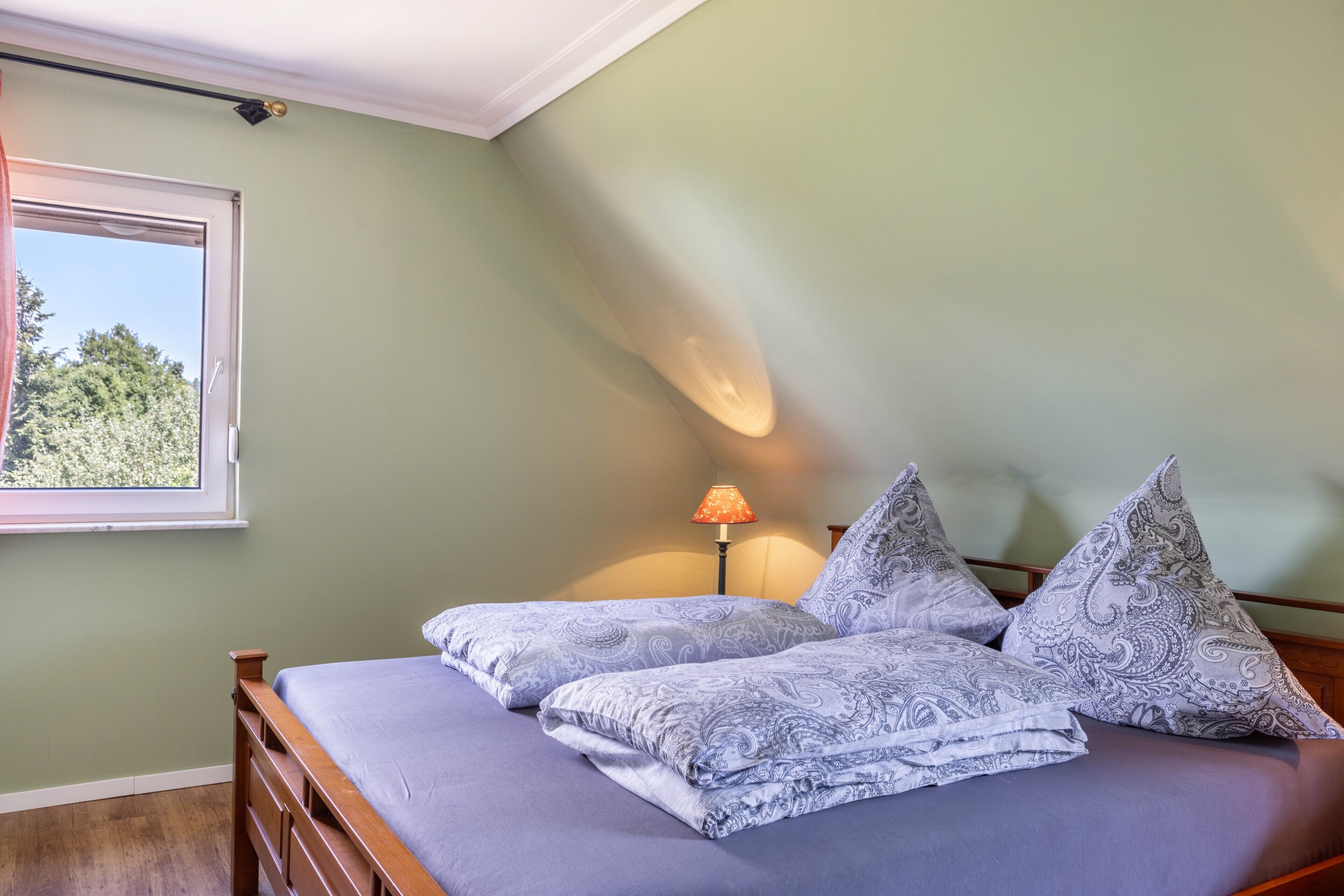 Une chambre à coucher avec un lit, une fenêtre et une lampe.