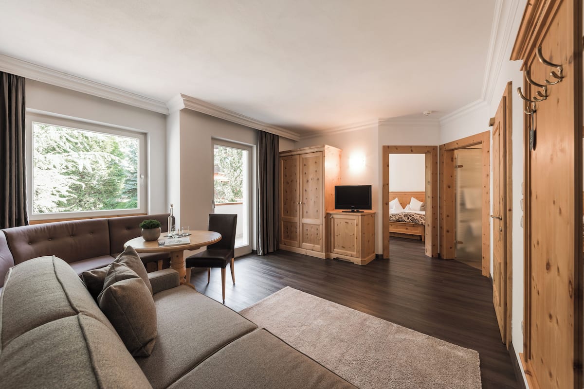 Un salon moderne avec un canapé, une table à manger et un téléviseur. On y trouve des meubles en bois et une cheminée.