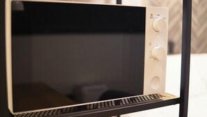 A microwave with a digital display and three control knobs. - TAKETO STAY PREMIERE 201 (Sapporo)