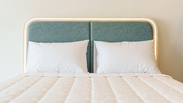 A bed with a headboard, two pillows, and a white mattress. - Donghae Neulbadarang Ocean View Pension (Donghae)