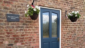 Una puerta azul con un letrero que dice 'The Old Coach House'.