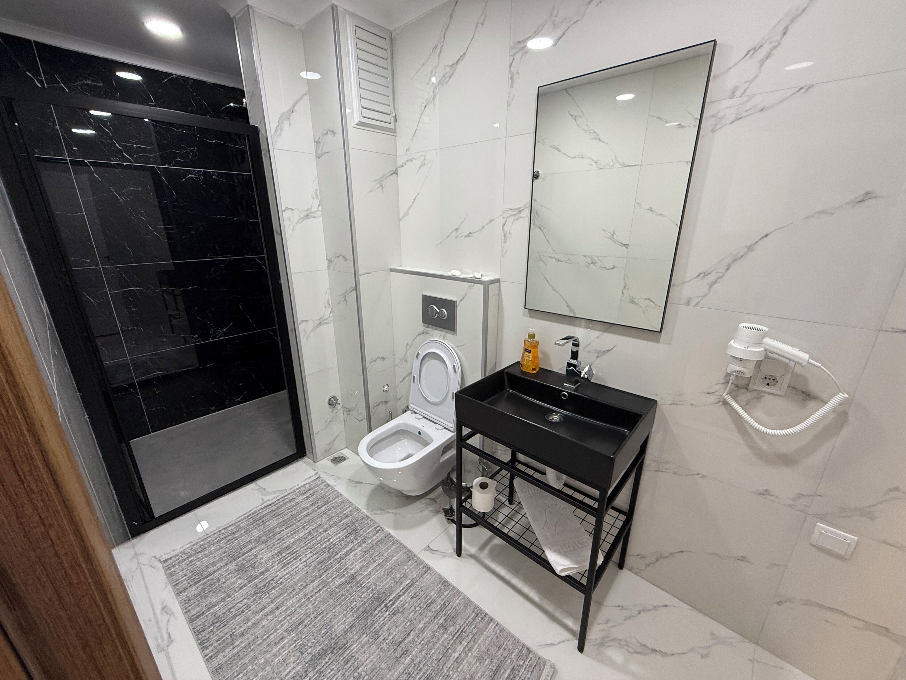 A modern bathroom with a toilet, sink, and shower.