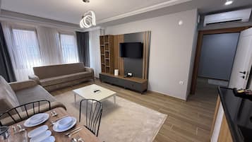 Deluxe Apartment, Balcony, Partial Sea View | Living area | 108-cm Smart TV with satellite channels, heated floors, printers