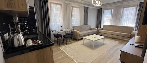 Appartement Deluxe, balcon, vue partielle sur la mer | Aire de séjour | Téléviseur connecté, planchers chauffants, imprimante