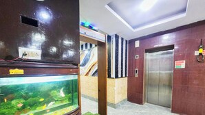 Een hal met een aquarium, een lift en een trap.
