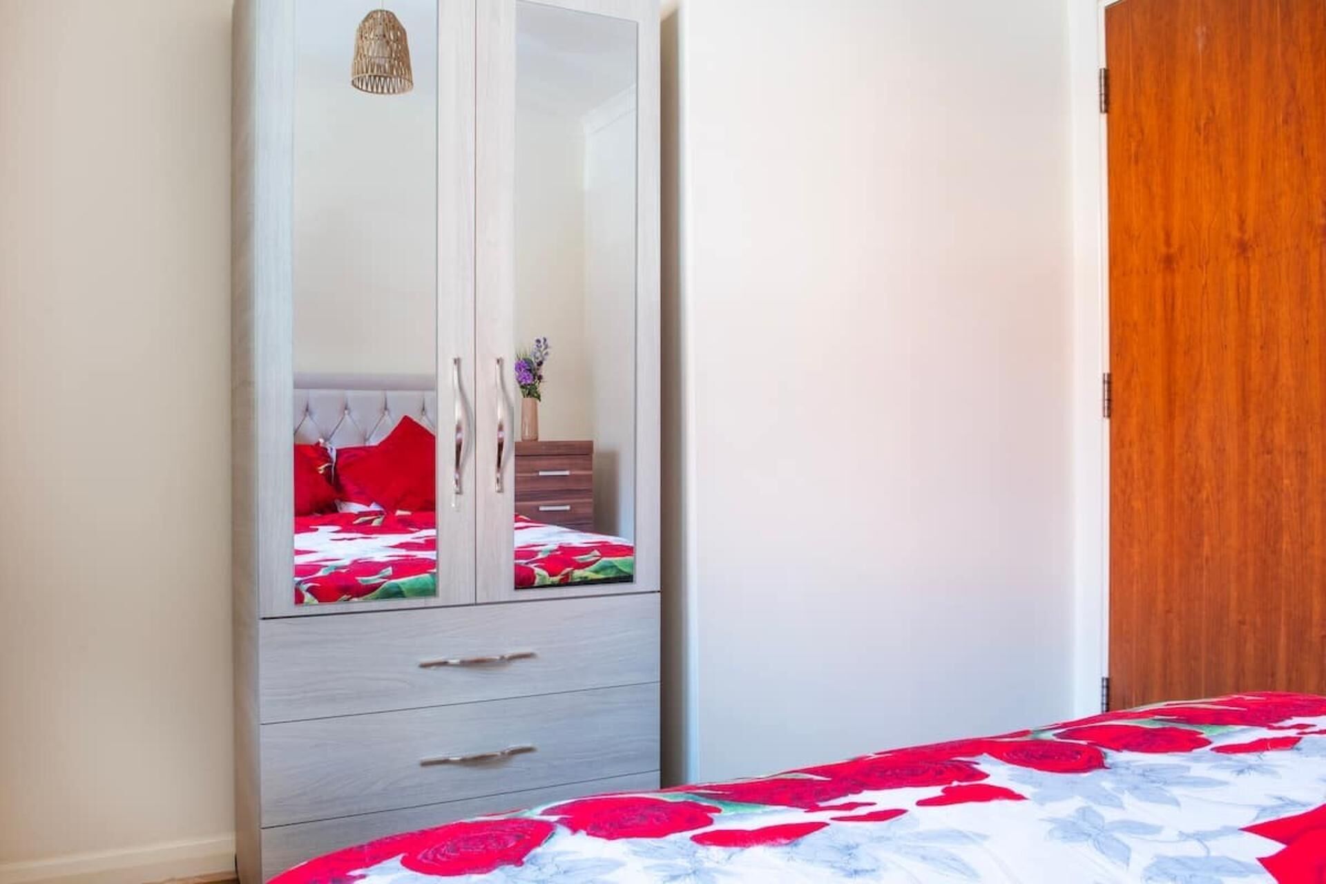 A bedroom with a bed, a wardrobe, and a wooden door.