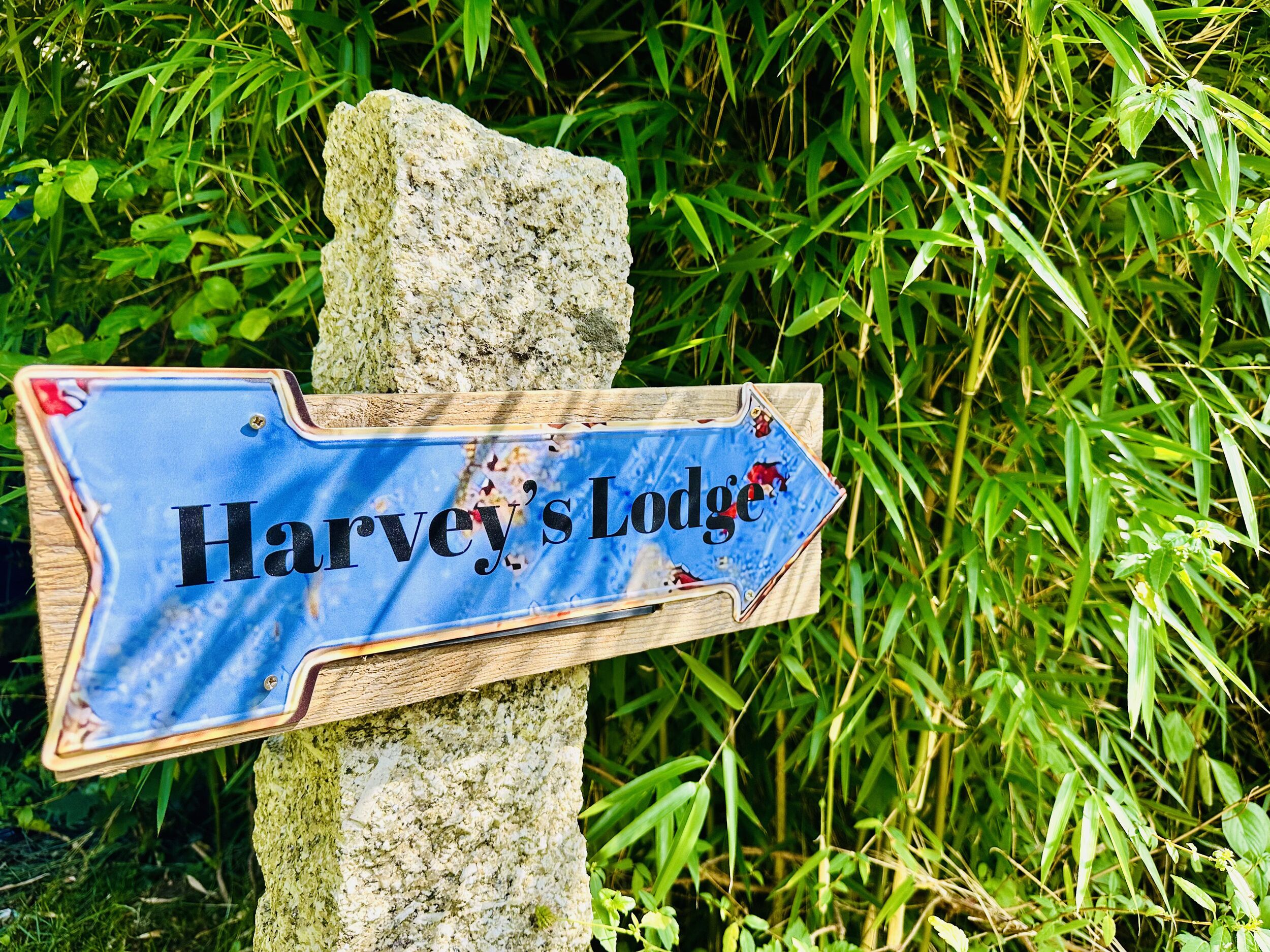 A directional sign for Harvey's Lodge.