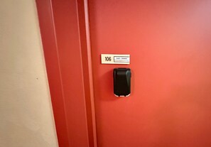 Eine rote Tür mit Kartenlesegerät und einem Schild darüber.