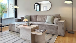 Een moderne woonkamer met een modulaire bank, een salontafel en een vloerlamp.