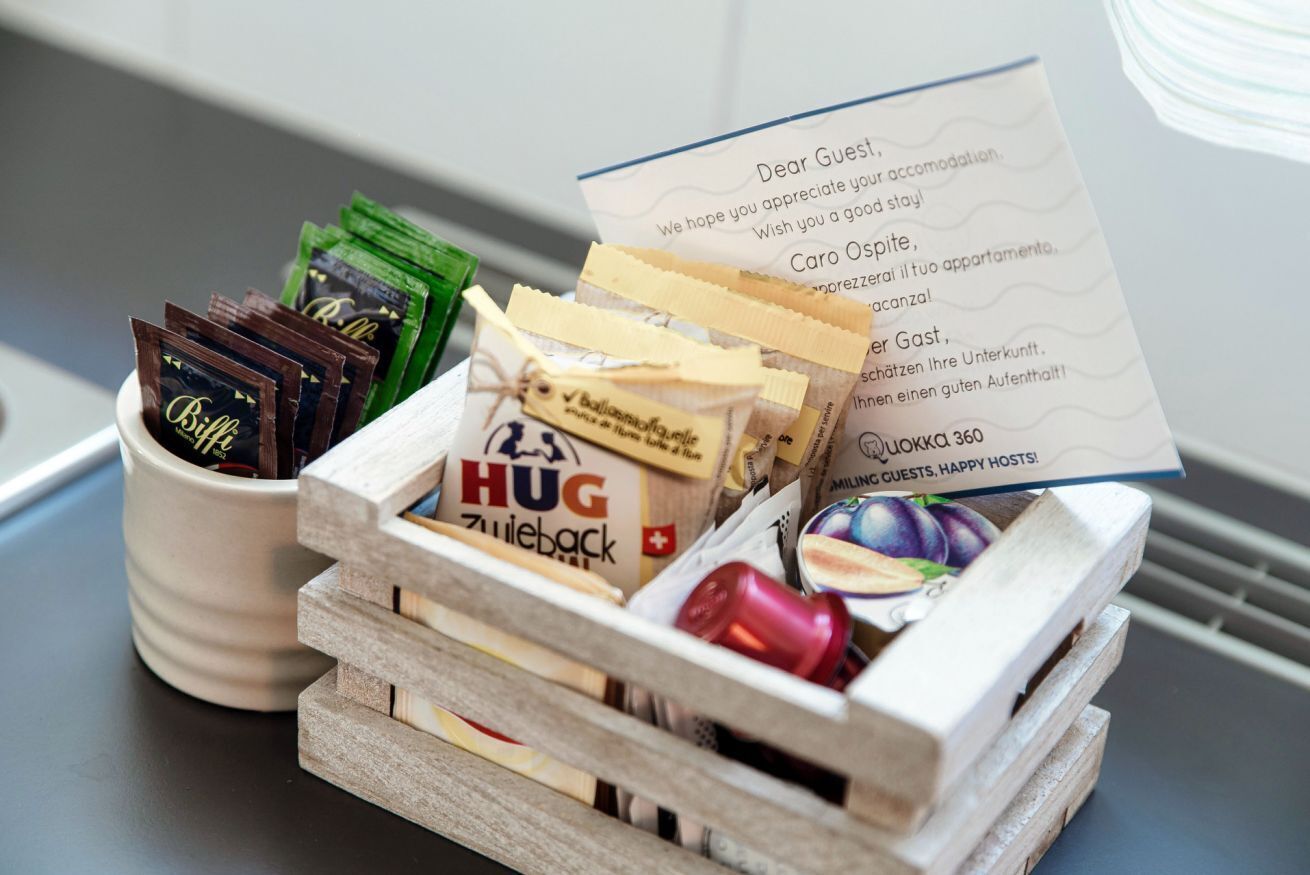 Une caisse en bois contenant des barres de chocolat, une tasse et un mot.