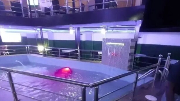 Una piscina con barandilla metálica y fuente de agua.