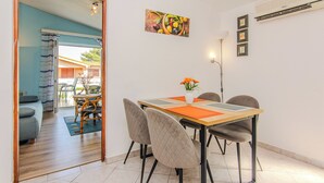 A dining area with a table, chairs, and a vase of flowers. - Apartment Semak (Vir)