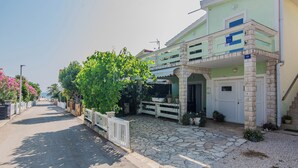 A two-story building with a stone-paved entrance and a balcony. - Apartment Semak (Vir)